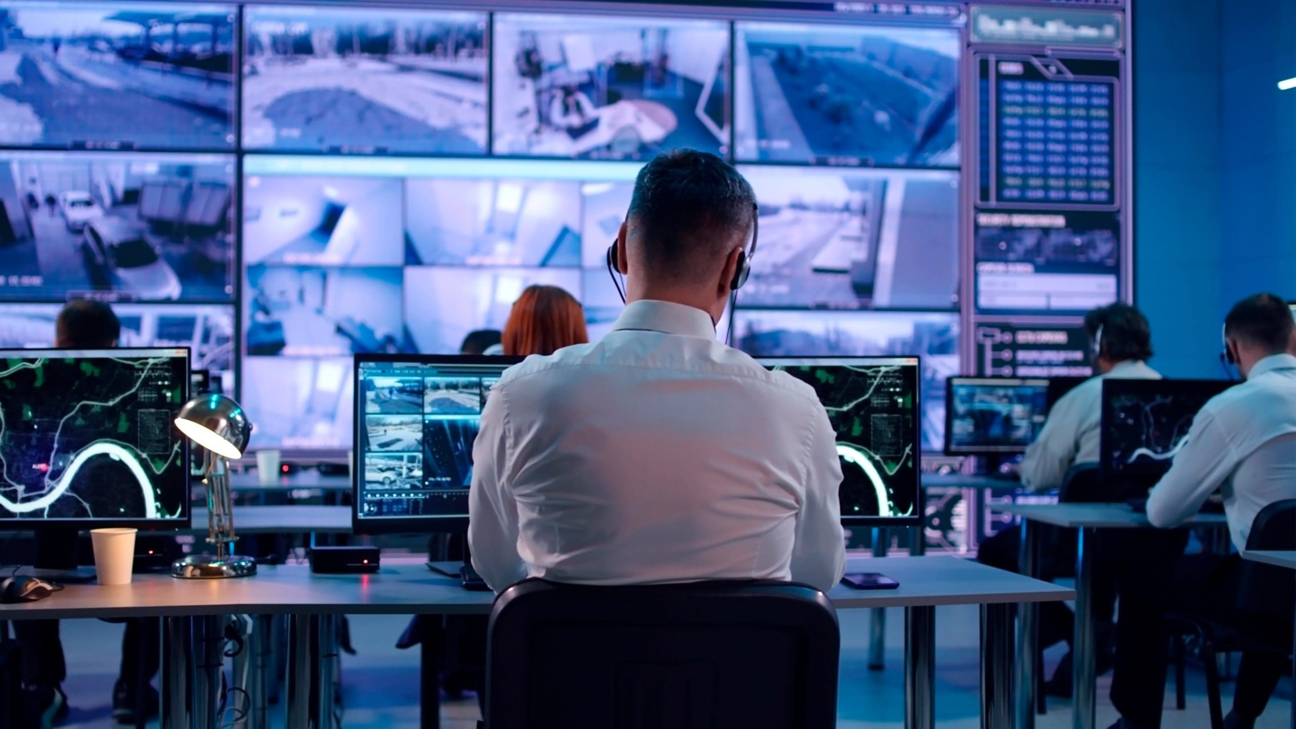Male spy browsing video and map on computers